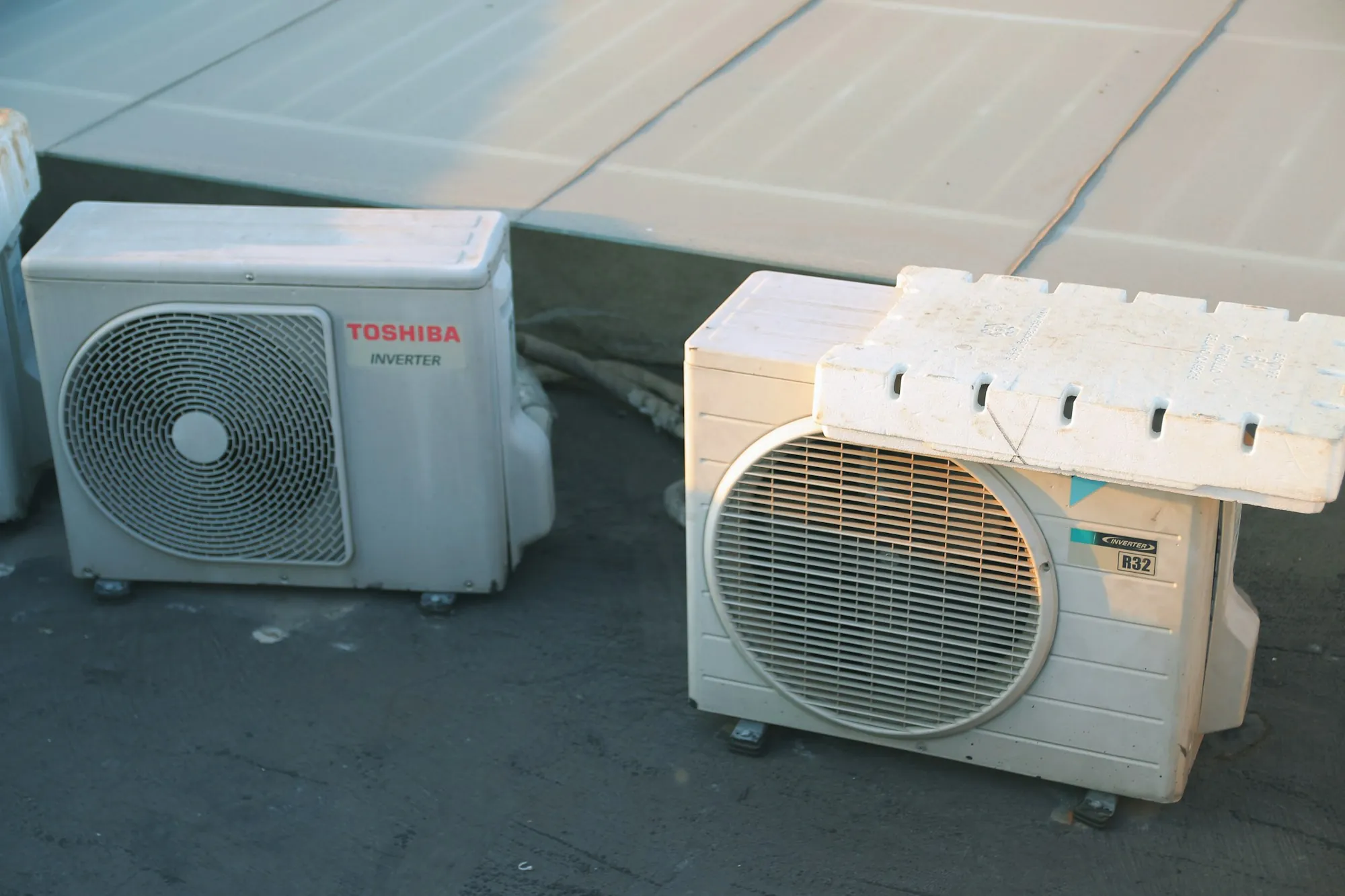 Two condenser units sitting on a flat roof